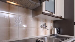 A modern kitchen with a stainless steel sink, a kettle, and a range hood. - One Bedroom Apartment with Terrace (Vrboska)