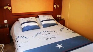 A hotel room with a bed, two bedside tables, a nightstand, and a wardrobe. - FULLY EQUIPPED MOBIL HOME with large 30 M2 terrace and small garden. (Saint-Augustin)