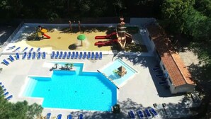 A swimming pool with sun loungers, a slide, and a small play area. - FULLY EQUIPPED MOBIL HOME with large 30 M2 terrace and small garden. (Saint-Augustin)