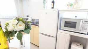 A kitchen with a microwave, a toaster, and a refrigerator. - Suzuka Smile Room (Suzuka)