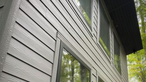 A house with a gabled roof and multiple windows. - **Cleaning Fee Included** Mini modern cabin nestled in the peaceful hills between Jackson and Putnam County, minutes away from CUMMINS FALLS STATE PARK. Designed for comfort and style, this vacation rental seamlessly blends modern charm with wooded s (Cookeville)