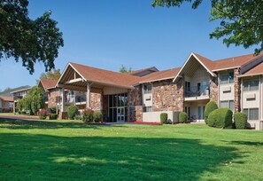 A row of multi-story buildings with stone facades, large windows, and balconies. - Grand Lake | Couples Lake Retreat | Pool + Hot Tub (Afton)