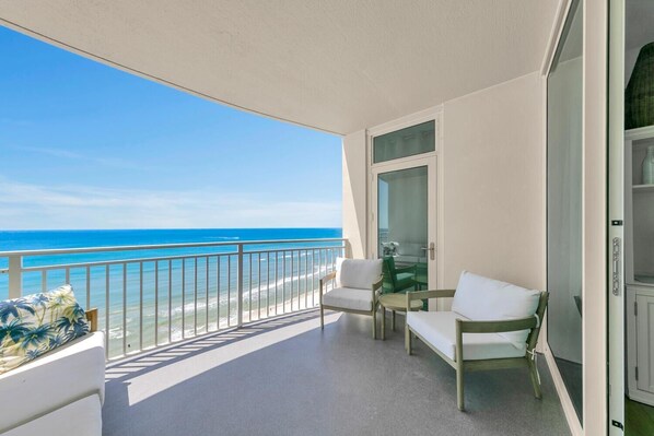 Un balcon avec vue sur la plage et l’océan.