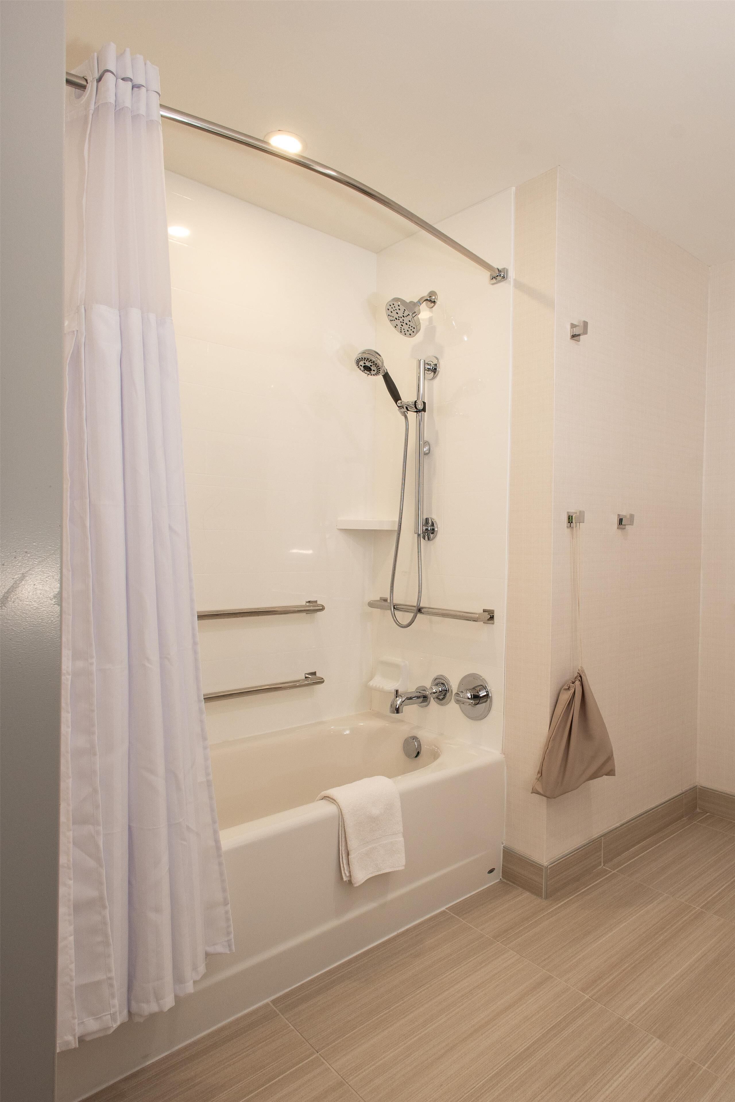 A modern bathroom with a bathtub, shower, and a glass-enclosed shower area.