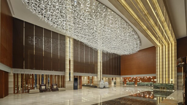 A spacious lobby with a high ceiling, a modern reception desk, and seating areas. - Hilton Harbin Exhibition Center (Harbin)