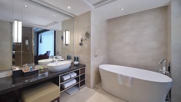 Un baño moderno con una bañera independiente grande, un tocador con doble lavabo y un espejo amplio.