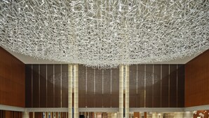 A spacious lobby with a high ceiling, large vertical columns, and a reflective floor. - Hilton Harbin Exhibition Center (Harbin)