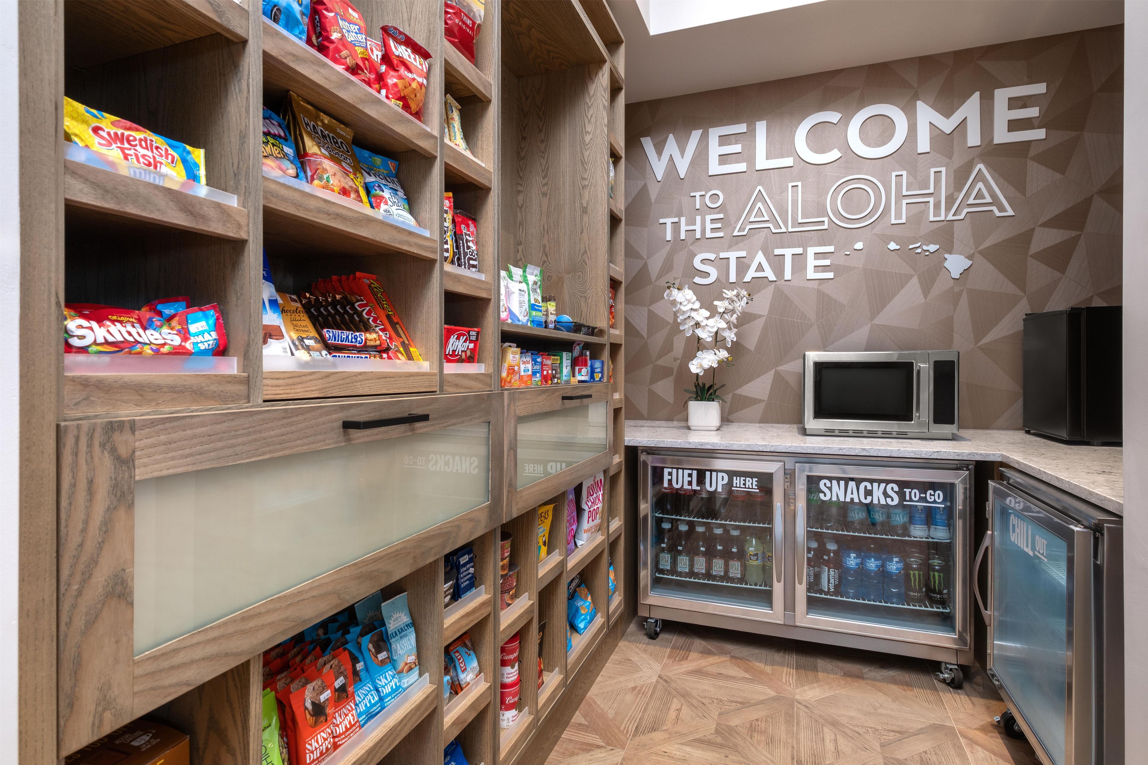 A snack display area with various packaged snacks and a welcome sign for the state of Hawaii.