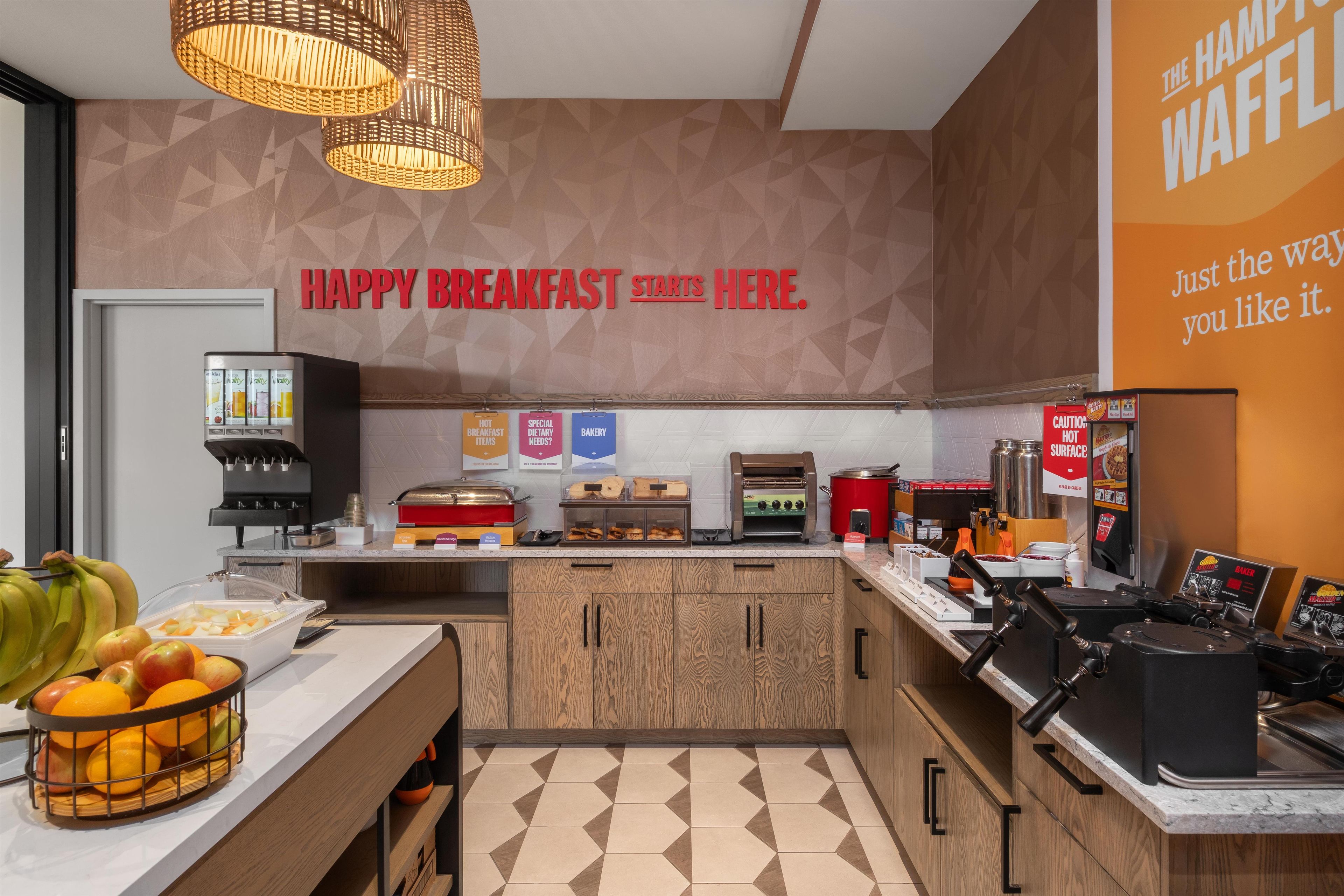 A breakfast area with a sign that reads 'HAPPY BREAKFAST STARTS HERE.'