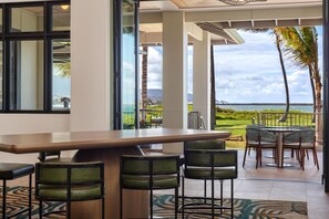 A bar area with a view of the ocean and a golf course. - Hampton Inn & Suites Maui North Shore (Kahului)