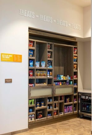 A snack display with various packaged treats and a sign that reads "We've got what you forgot." - Hampton Inn & Suites Maui North Shore (Kahului)