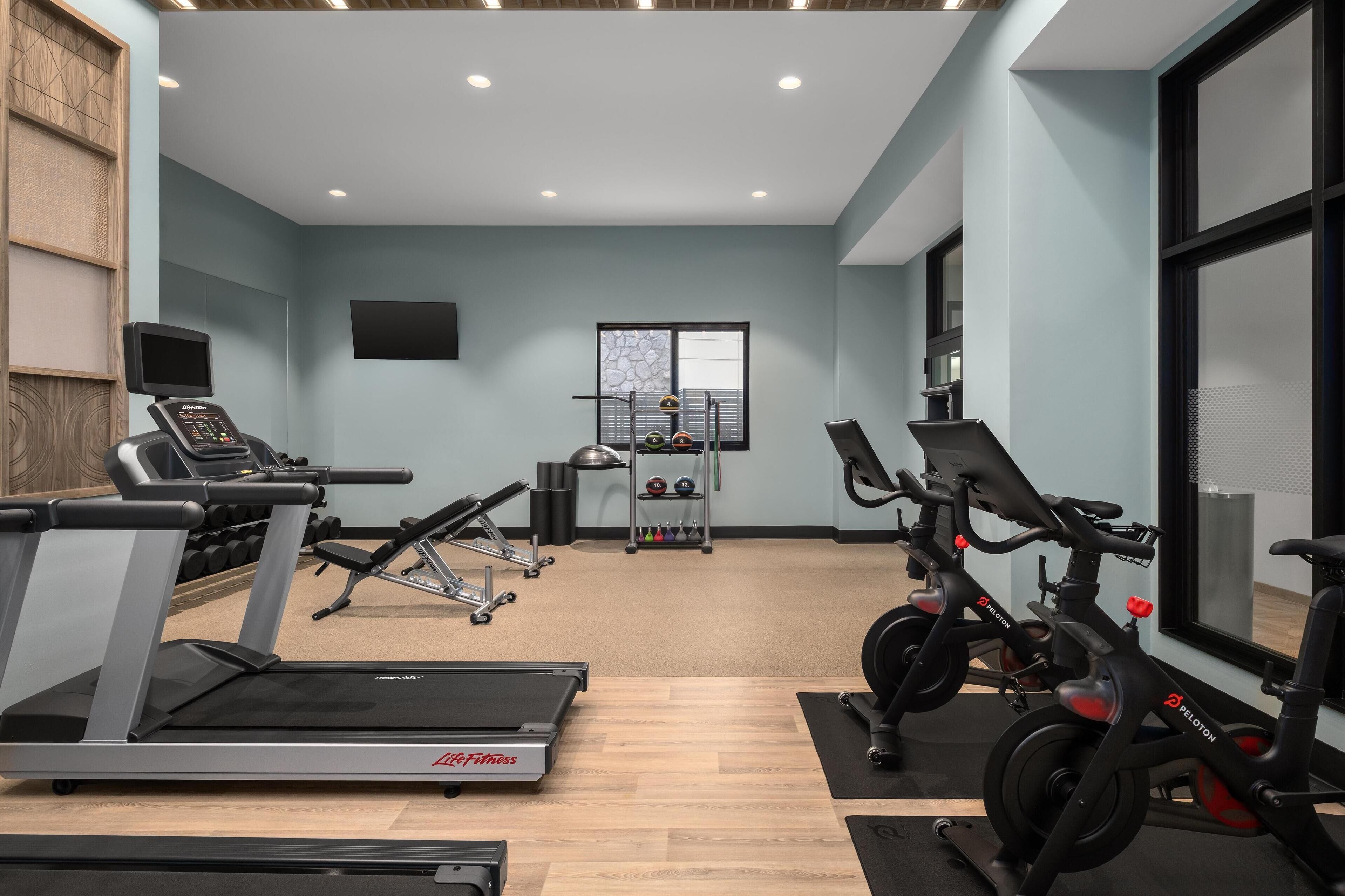 Una palestra con tapis roulant, ellittiche e cyclette.