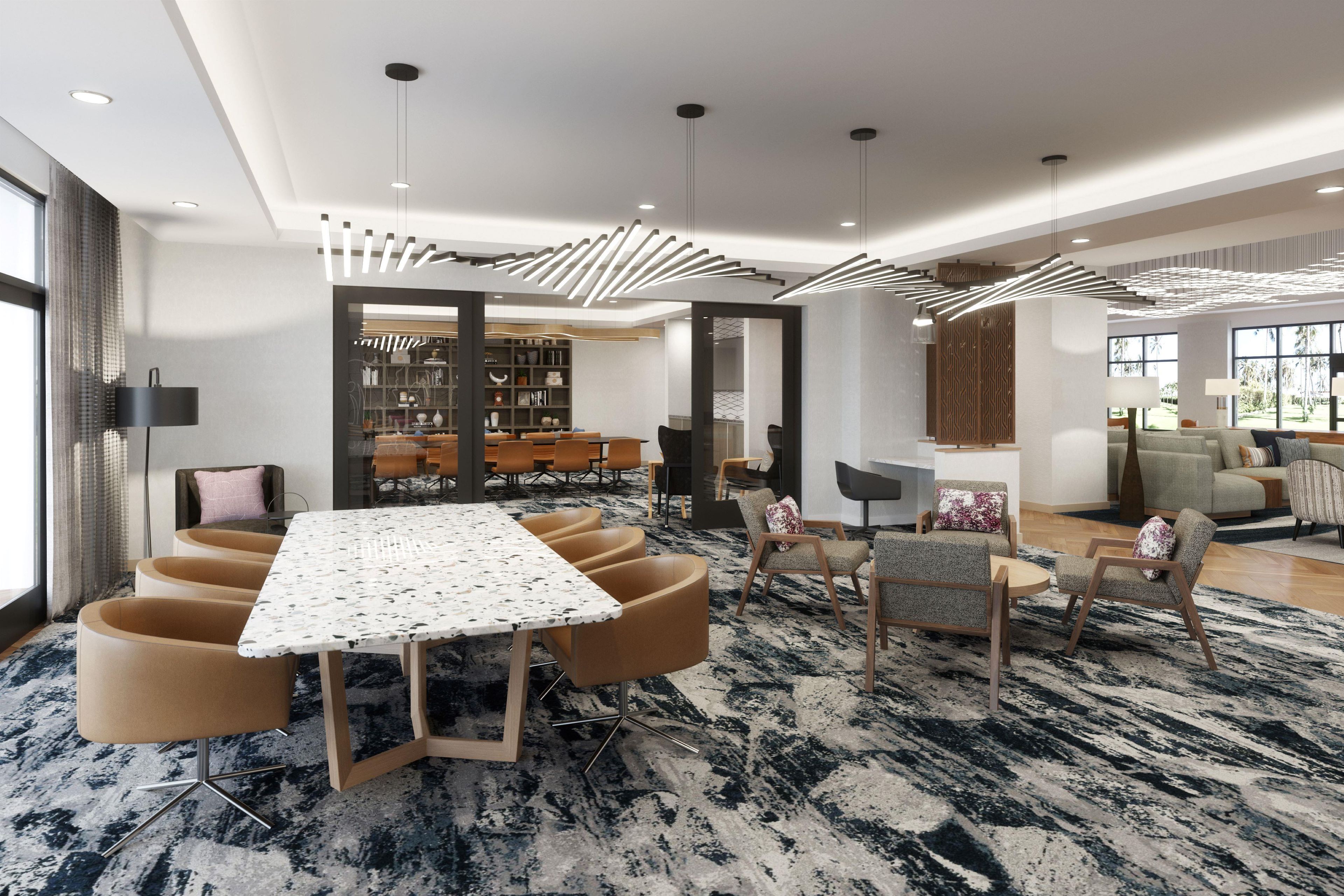 A modern hotel room with a dining area featuring a marble table and contemporary chairs.