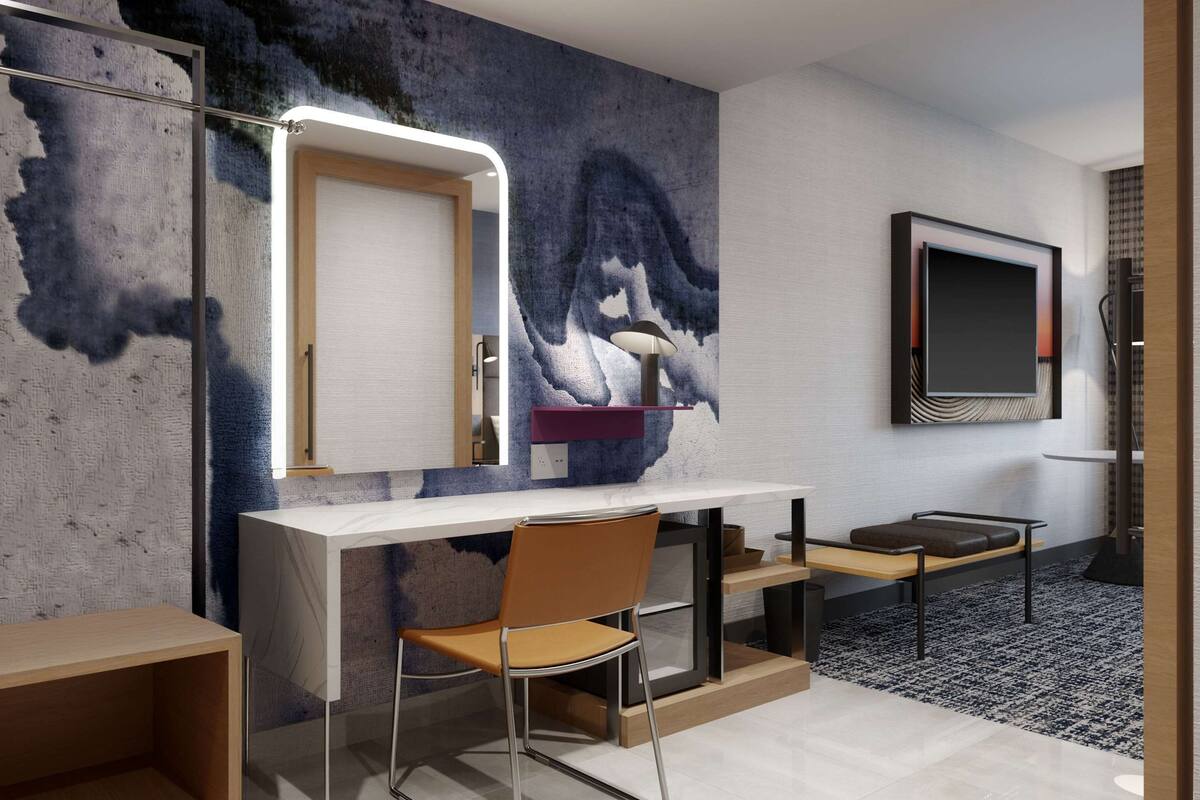 Een moderne kamer met een grote spiegel, een bureau en een stoel.