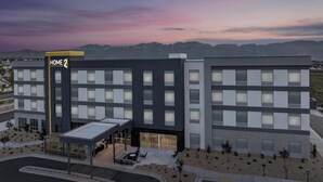 A modern hotel building with a "Home 2" sign, multiple floors, and a covered outdoor seating area. - Home2 Suites By Hilton Tooele (Tooele)