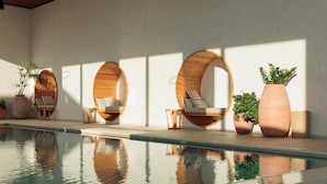 A poolside area with three wooden hanging chairs, potted plants, and a clear pool. - Hotel Preko Ugljan Island, Curio Collection By Hilton (Preko)