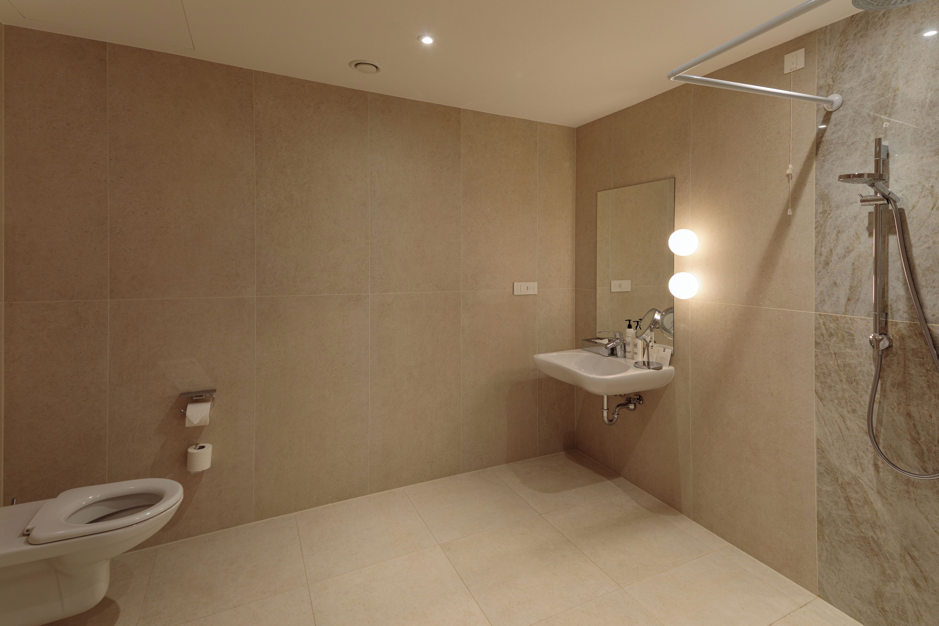 A modern bathroom with a toilet, sink, and shower.