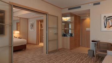 A hotel room with a bed, a desk, a chair, a wardrobe, and a bathroom.