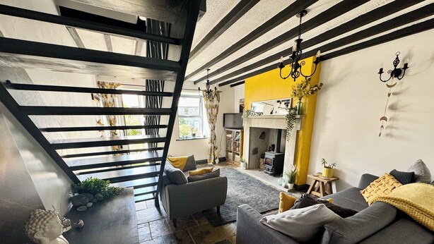 Un salon moderne avec un escalier, une cheminée et un coin salon confortable.
