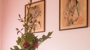 A table with a bottle of Valdo wine, two glasses, a vase with flowers, and a bowl of fruit. - Montello Hill front property with large garden (Ciano)