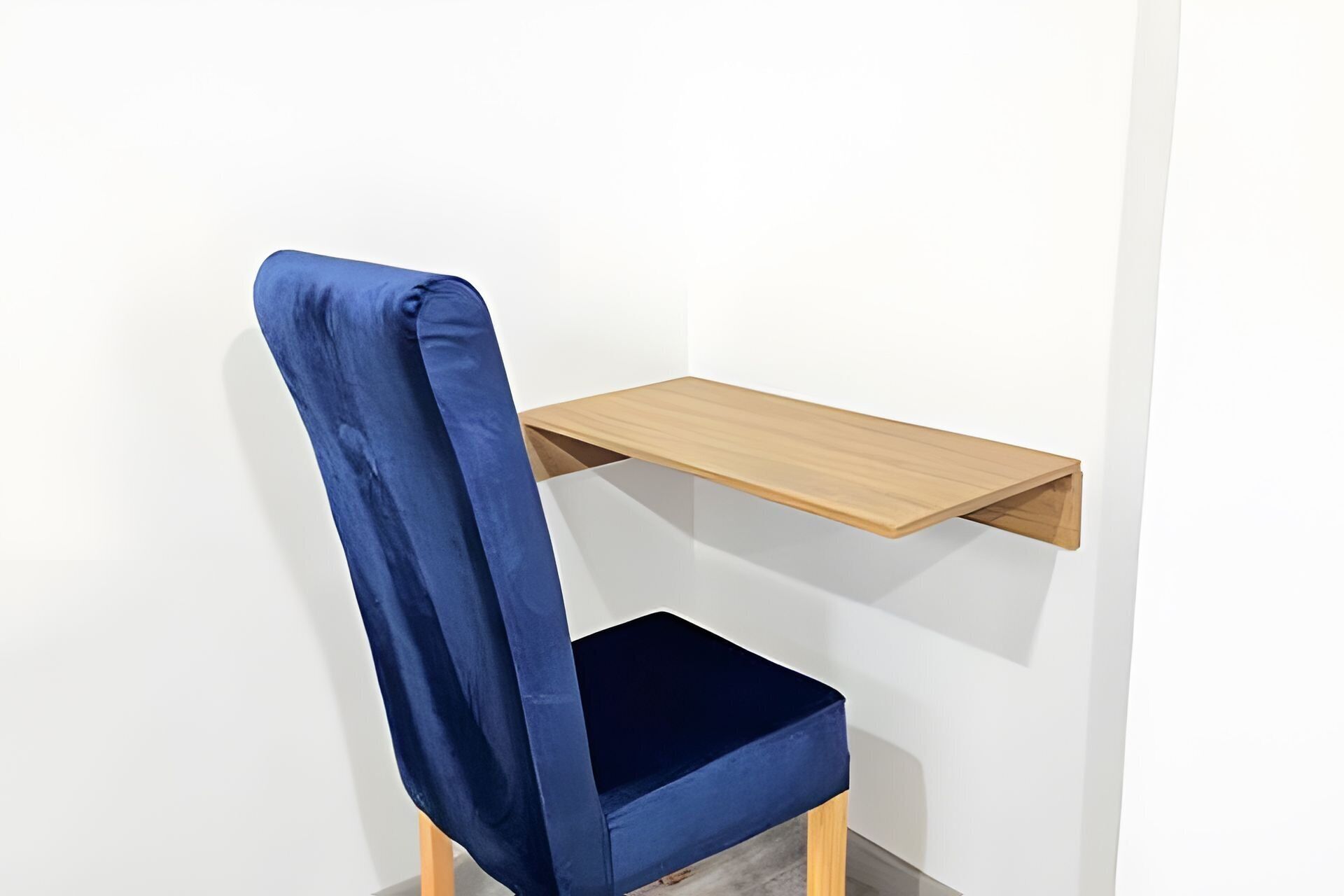A chair with a blue cushion and a wooden shelf attached to the wall.