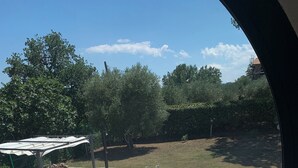 Une piscine avec un ciel bleu dégagé, entourée de parasols et délimitée par une clôture.