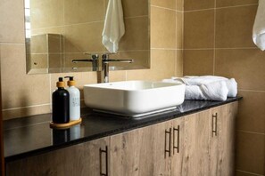 Een douche, handdoeken, zeep, toiletpapier