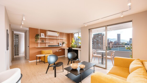 Um apartamento moderno com cozinha, sala de jantar e uma varanda grande com vista para a cidade.