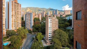 Um edifício alto com vários andares, rodeado por árvores e outros edifícios.