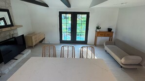 Un amplio salón con una gran mesa, sillas de madera, un sofá y una chimenea.
