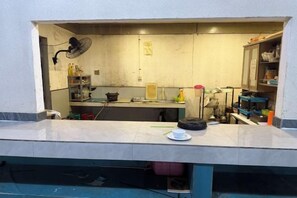 Una cocina con una encimera, armarios y diversos utensilios de cocina.