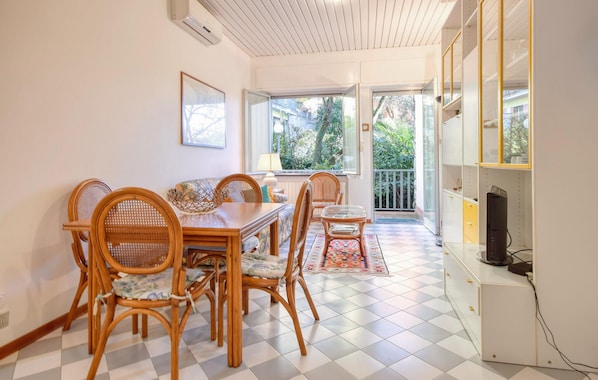 A dining area with a checkered floor, wooden chairs, a dining table, and a view of greenery outside. - 2 bedroom nice apartment in Chiavari (Chiavari)