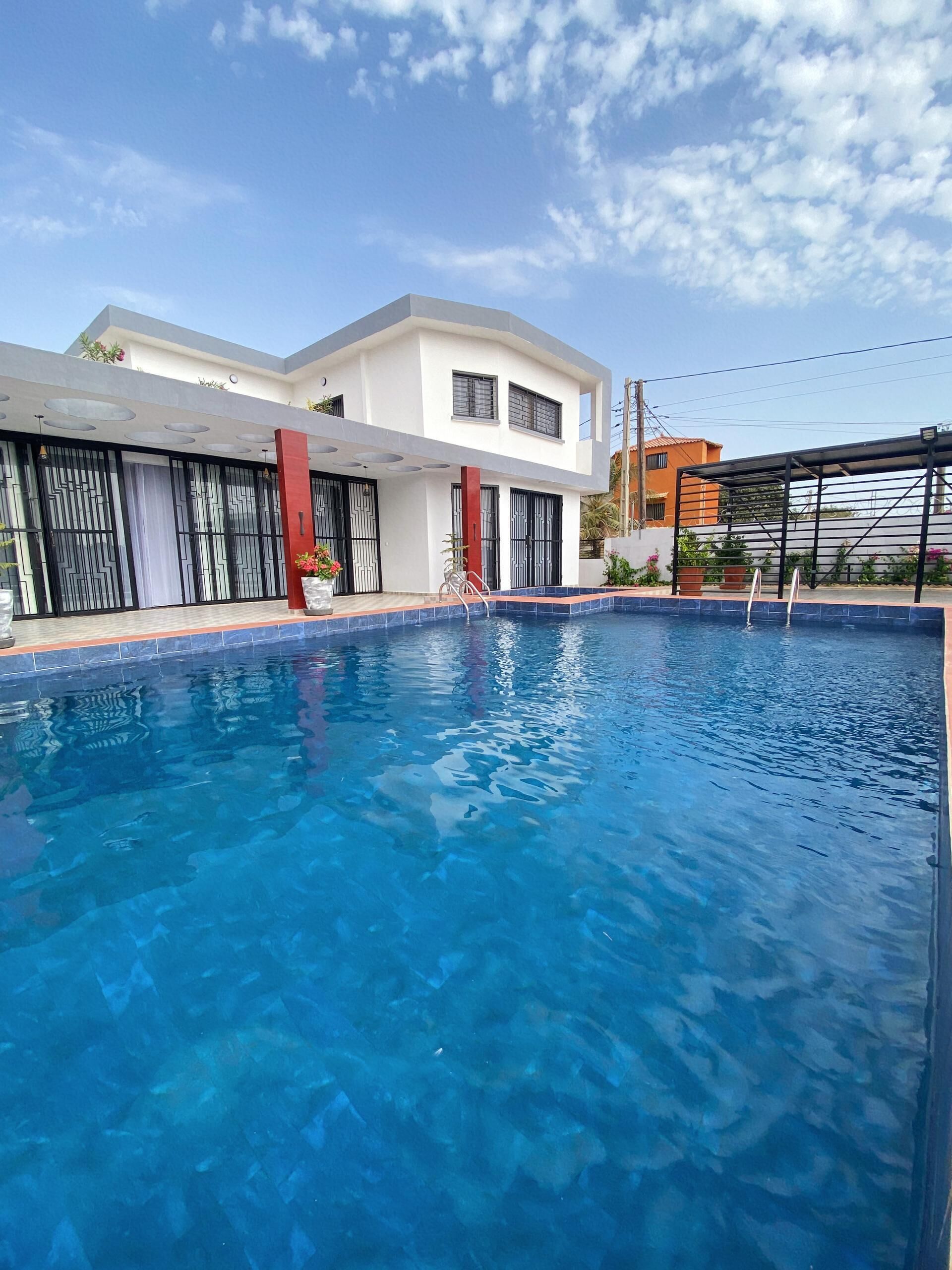 A swimming pool with a modern house in the background.
