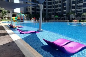 A swimming pool with water slides and a children's play area. - Atlantis Residence by Jeffery Lam Home Management (Melaka)