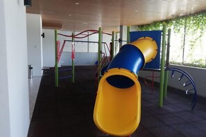 A playground with a slide and climbing structures. - Atlantis Residence by Jeffery Lam Home Management (Melaka)