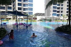 Un área de piscina con sillones de descanso y sombrillas.