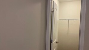 Una puerta cerrada con marco blanco, un picaporte visible y un pequeño espacio en la parte superior.