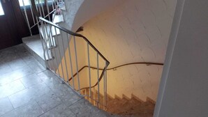 Una escalera con barandilla metálica y pared con relieve.