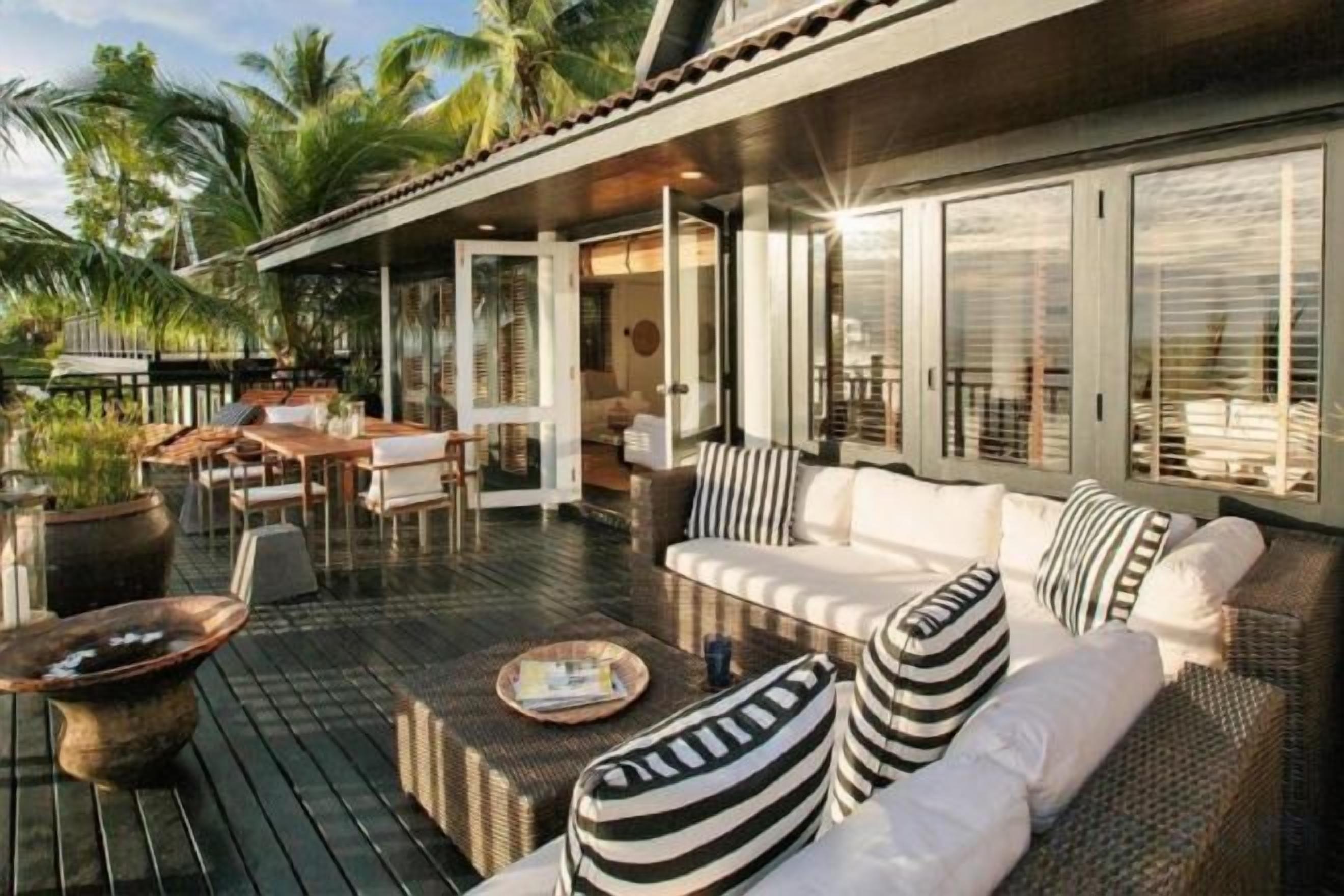 An outdoor seating area with a sofa, chairs, and a dining table.