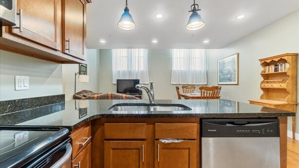 A kitchen with wooden cabinets, a dishwasher, a stove, and pendant lights. - Quiet spacious apartment  sleeps 4. 1br plus den. (Albany)