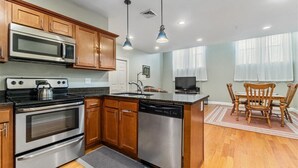 A modern kitchen with wooden cabinets, stainless steel appliances, and a central island. - Quiet spacious apartment  sleeps 4. 1br plus den. (Albany)