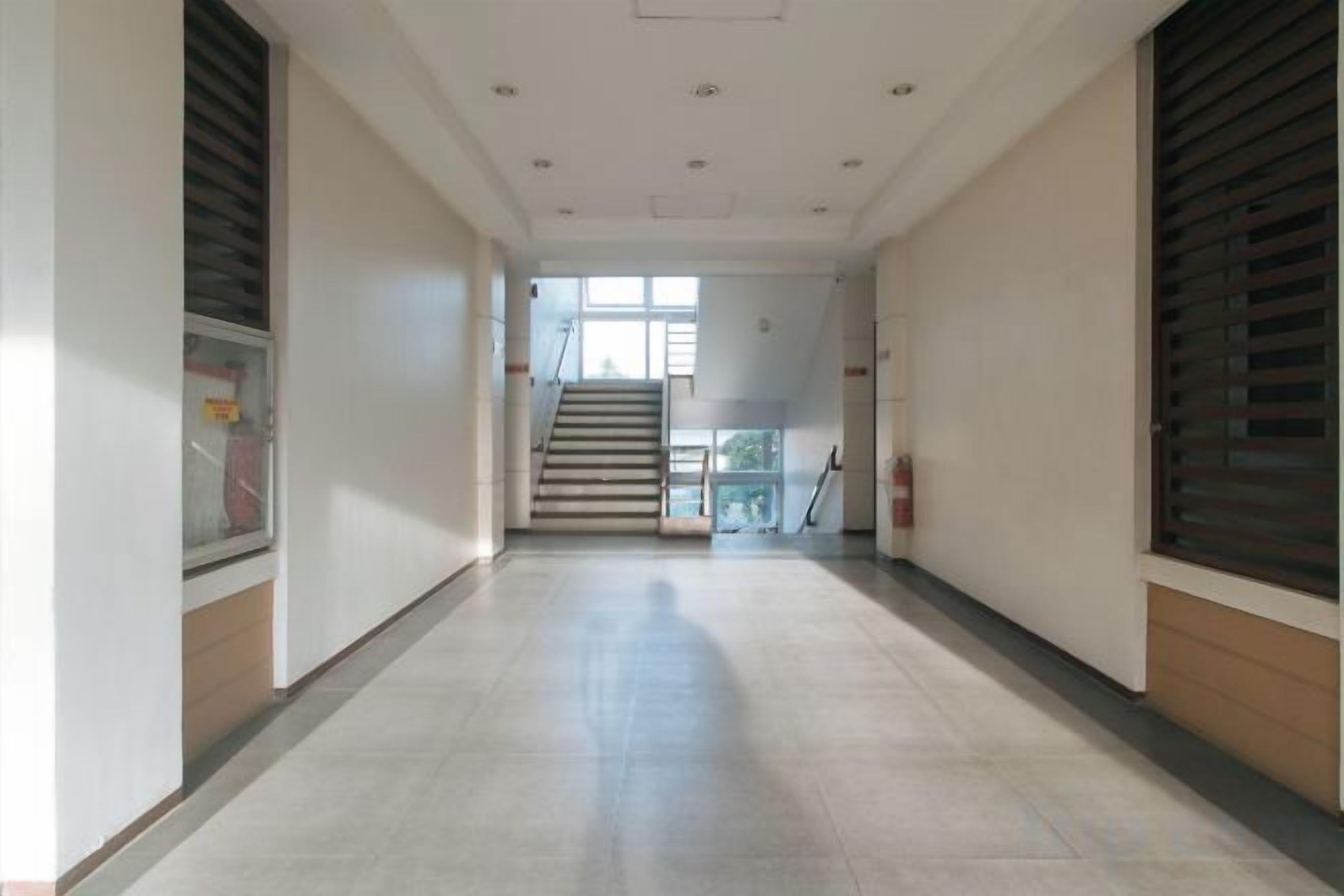 A corridor with a staircase leading to an upper level.