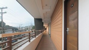 A corridor with a wooden railing and a door on the right. - RedDoorz @ Traveler Inn Matina (Davao City)