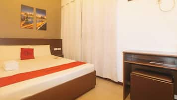 Ein Hotelzimmer mit einem Bett, einem Schreibtisch und einem Vorhangfenster.