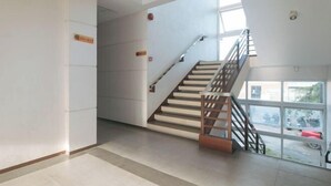 A modern interior with a staircase, a fire alarm, and a view through large windows. - RedDoorz @ Traveler Inn Matina (Davao City)