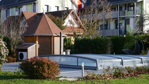 Et boligområde med et moderne hus, et mindre udhus og et grønt tag.