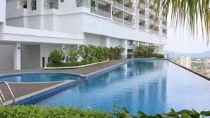 A modern hotel with a long, narrow swimming pool surrounded by lush greenery and a white building facade. - Sliverscape Premier Suite @ Melaka Raya [Bathtub Sleep 2-4] (Melaka)