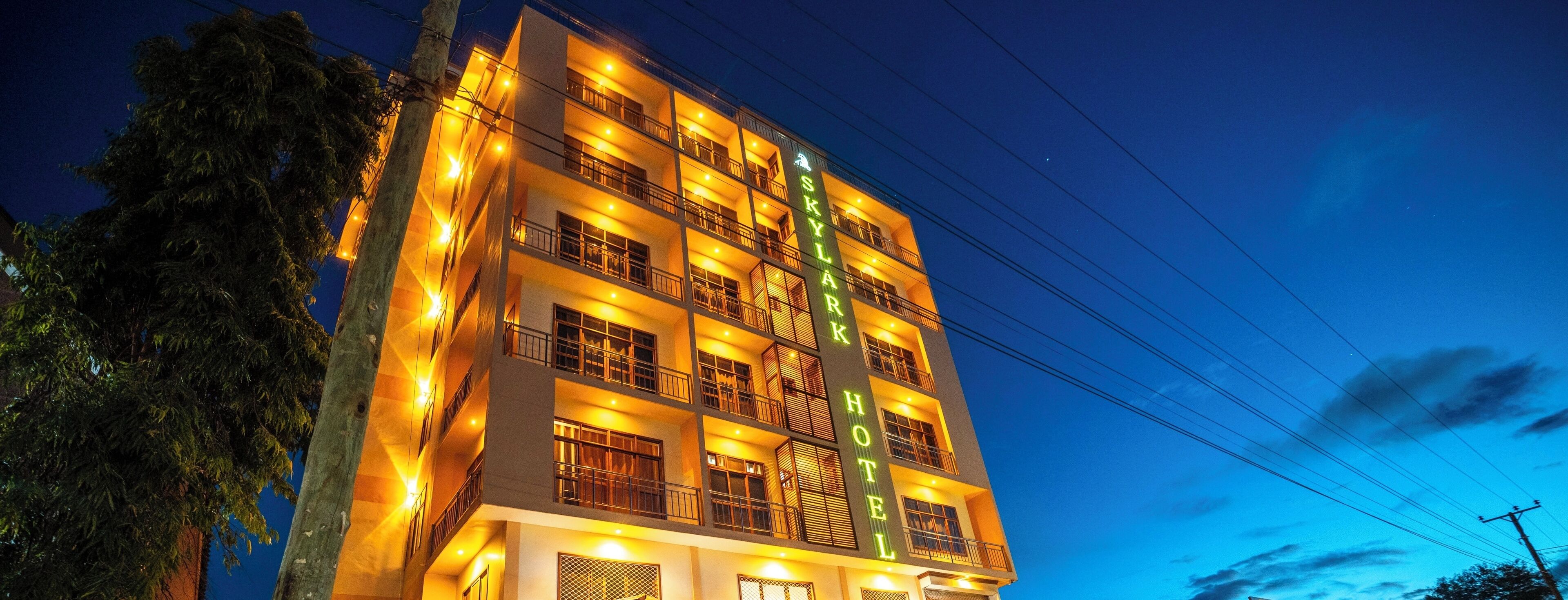 Un hotel de varios pisos con balcones y un cartel que dice "Skylar Hotel".