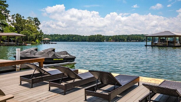 A lakeside dock with lounge chairs, a covered area, and a boat. - 3-bedroom Lake Martin, AL cabin in cool Equality with WiFi, AC (Equality)