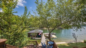 A lakeside deck with outdoor seating, a gazebo, and a dock. - 3-bedroom Lake Martin, AL cabin in cool Equality with WiFi, AC (Equality)